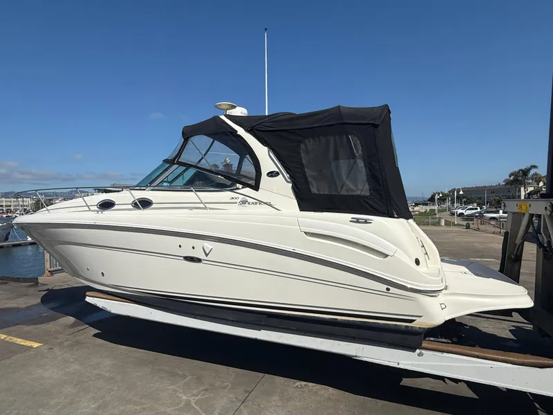 The Image of 2004 Sea Ray 300 Sundancer boat on trailer, dockside view. - 0