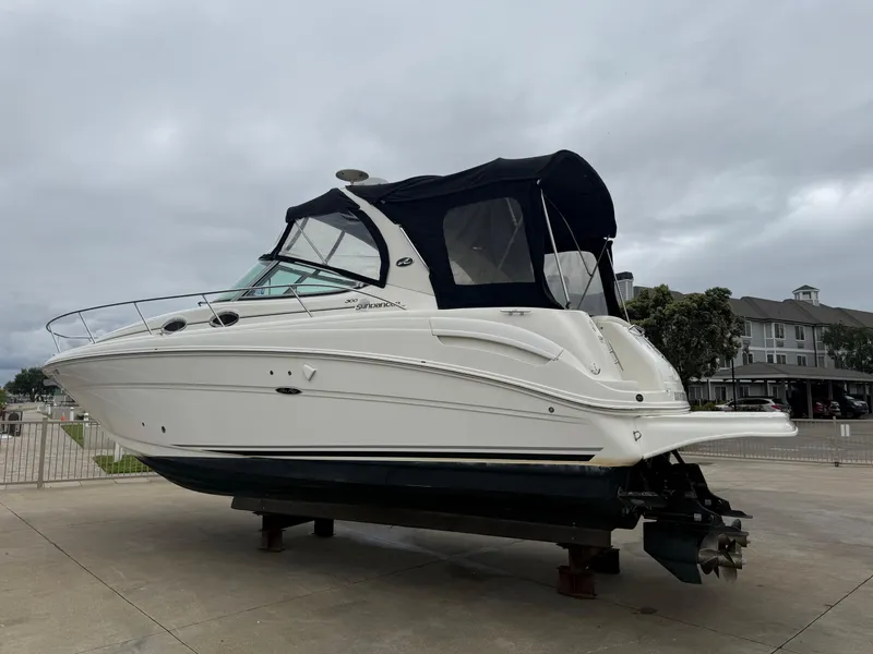 Slide: The Image of 2004 Sea Ray 300 Sundancer boat on display, featuring sleek design and black canopy. - 1