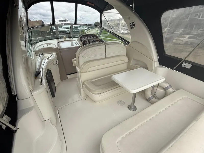 Slide: The Image of 2004 Sea Ray 300 Sundancer interior with seating and table, showcasing luxury boat design. - 12