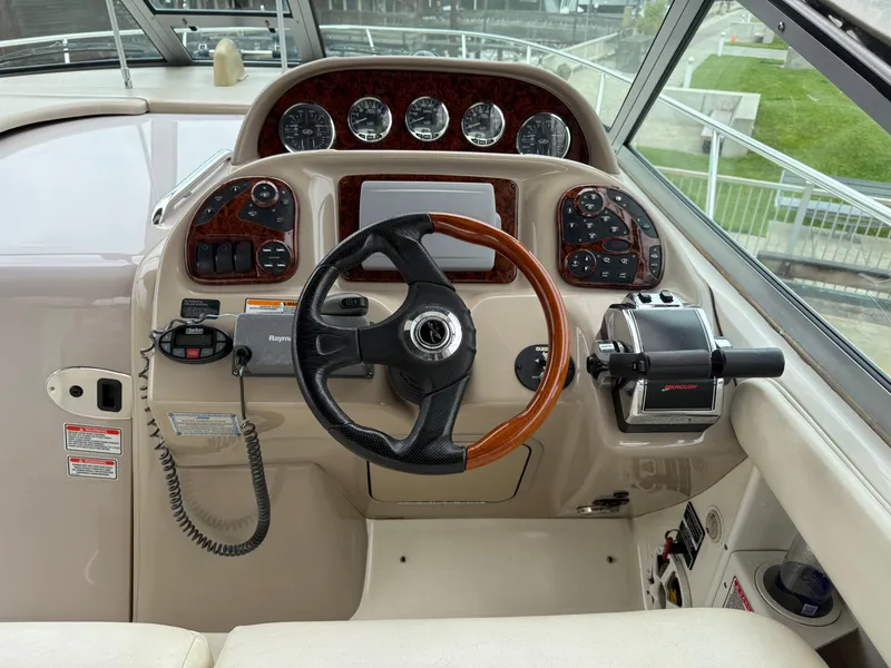 Slide: The Image of 2004 Sea Ray 300 Sundancer helm with steering wheel and control panel. - 15