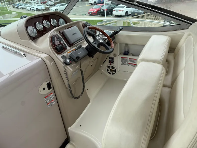 Slide: The Image of 2004 Sea Ray 300 Sundancer helm with beige seating and modern navigation controls. - 16