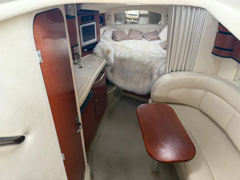 Slide: The Image of Interior of 2004 Sea Ray 300 Sundancer with cozy seating, kitchenette, and bed. - 19