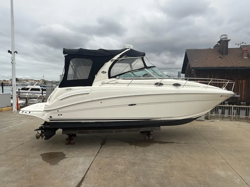 Slide: The Image of 2004 Sea Ray 300 Sundancer boat on dry dock, overcast sky background. - 5