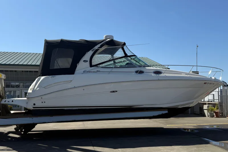 Slide: The Image of 2004 Sea Ray 300 Sundancer boat on a trailer, side view, with a blue canopy. - 7