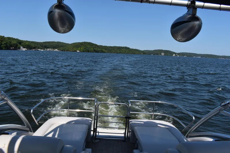 Slide: The Image of 2013 Bennington 2575 QCW I/O pontoon boat cruising on a scenic lake. - 16