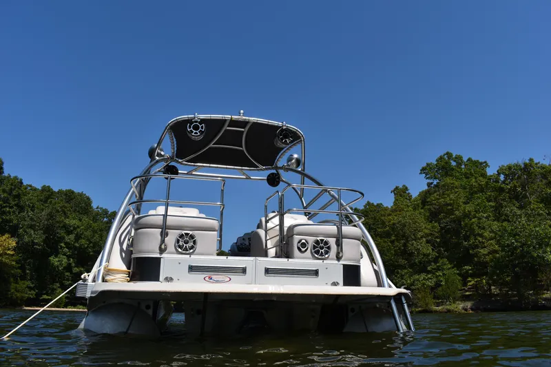 Slide: The Image of 2013 Bennington 2575 QCW I/O pontoon boat on a lake, surrounded by trees. - 17