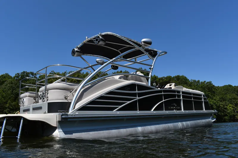 Slide: The Image of 2013 Bennington 2575 QCW I/O pontoon boat on a lake under clear blue sky. - 19