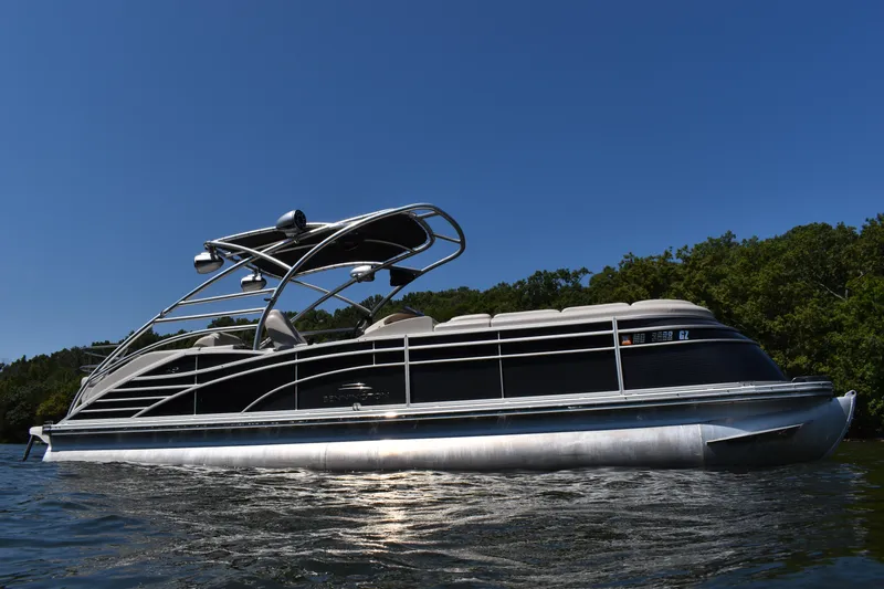 Slide: The Image of 2013 Bennington 2575 QCW I/O pontoon boat on water, clear sky background. - 20