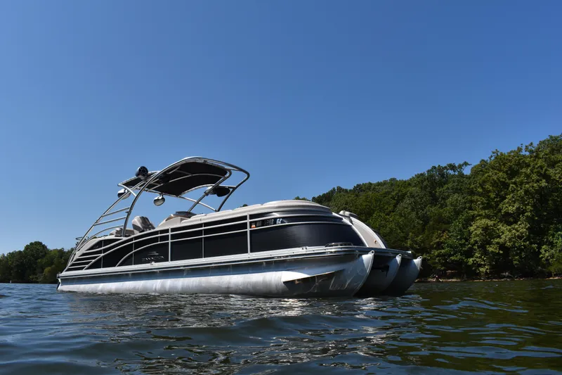 Slide: The Image of 2013 Bennington 2575 QCW I/O pontoon boat on a sunny lake. - 21