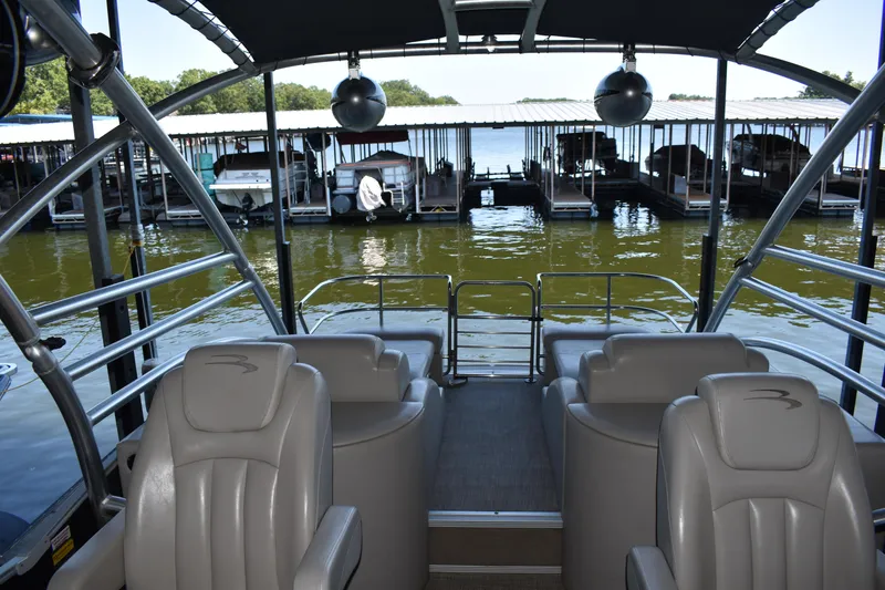 Slide: The Image of 2013 Bennington 2575 QCW I/O pontoon boat interior with dock view. - 22