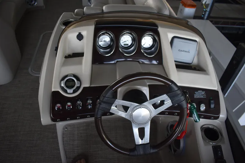 Slide: The Image of 2013 Bennington 2575 QCW I/O boat dashboard with steering wheel and gauges. - 24
