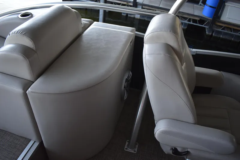Slide: The Image of 2013 Bennington 2575 QCW I/O boat interior with beige seating and storage compartment. - 30