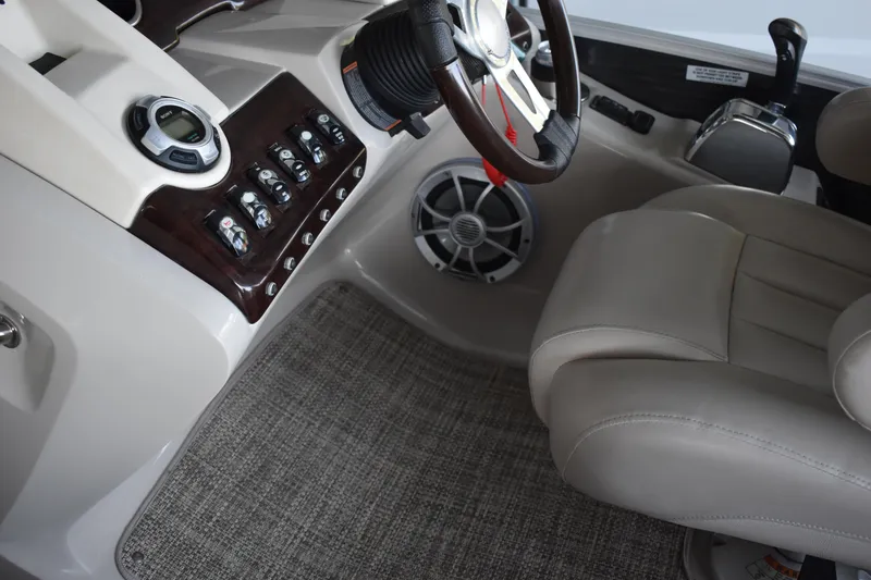Slide: The Image of Interior of a 2013 Bennington 2575 QCW I/O boat, featuring steering wheel and control panel. - 33
