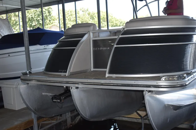 Slide: The Image of 2013 Bennington 2575 QCW I/O pontoon boat docked in a covered marina. - 36