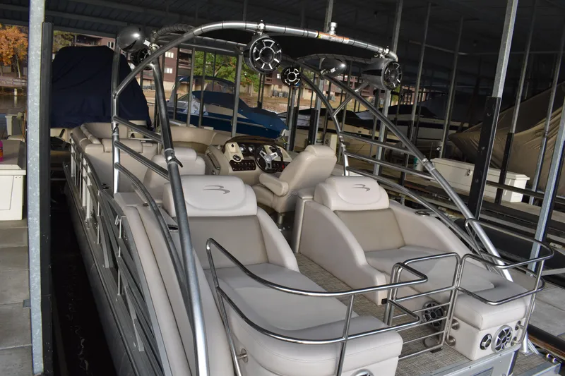Slide: The Image of 2013 Bennington 2575 QCW I/O pontoon boat with spacious seating and sleek design in a marina. - 4