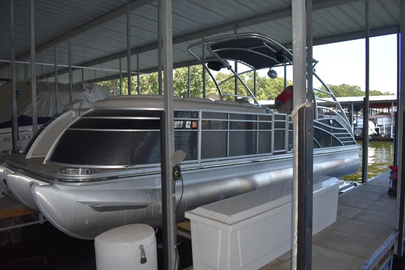 Slide: The Image of 2013 Bennington 2575 QCW I/O pontoon boat docked under a covered marina. - 40