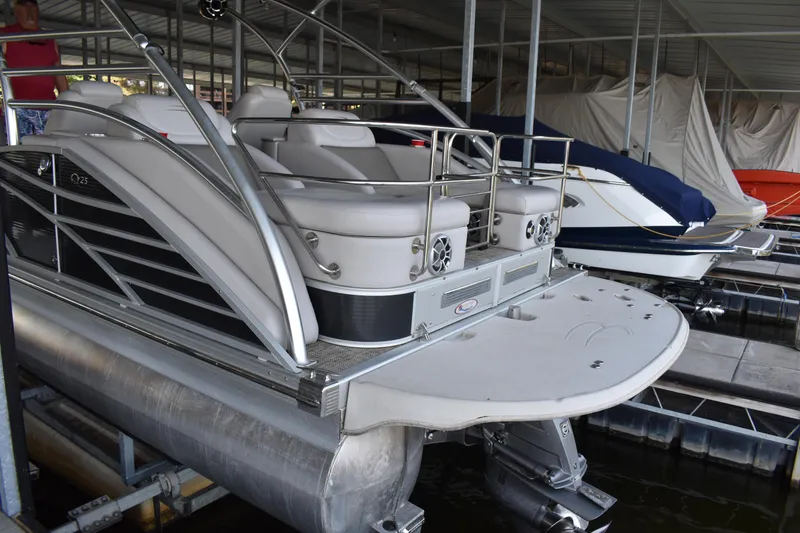 Slide: The Image of 2013 Bennington 2575 QCW I/O pontoon boat docked in a covered marina. - 44