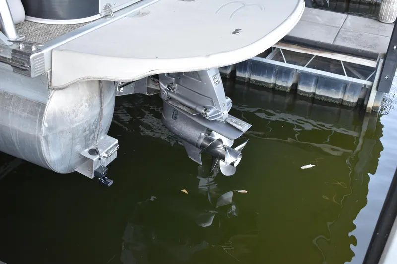 Slide: The Image of 2013 Bennington 2575 QCW I/O pontoon boat with visible outboard motor in water. - 45