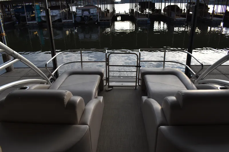 Slide: The Image of 2013 Bennington 2575 QCW I/O boat interior with plush seating, docked at marina. - 6
