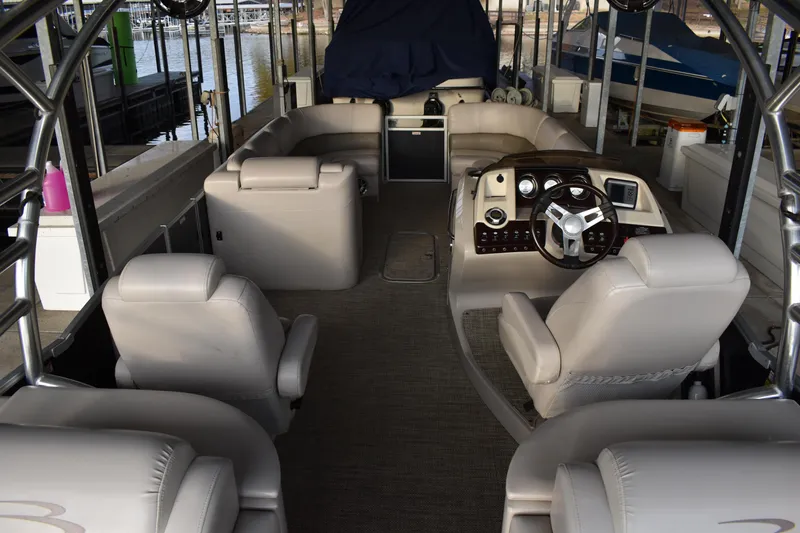 Slide: The Image of Interior of a 2013 Bennington 2575 QCW I/O boat with plush seating and steering console. - 8