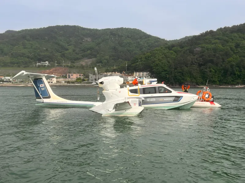 Slide: The Image of Futuristic Aron M 80 seaplane on water, surrounded by lush green hills, 2025 model. - 17