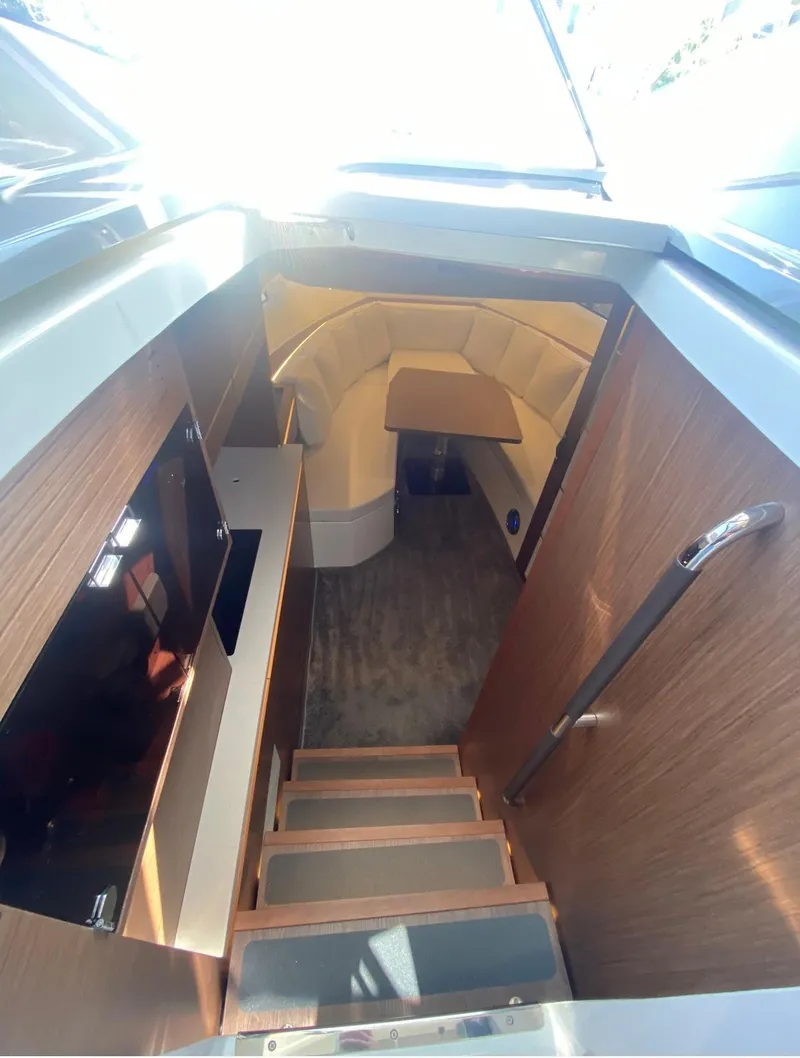 Slide: The Image of Interior view of 2021 Jeanneau Leader 12.5 WA yacht, featuring wooden stairs and modern design. - 11