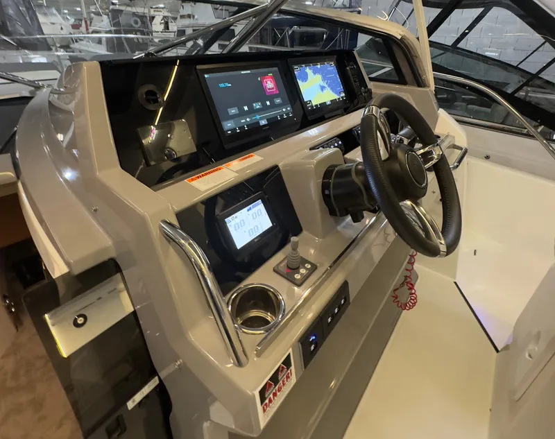 Slide: The Image of 2021 Jeanneau Leader 12.5 WA helm with modern navigation displays and steering wheel. - 18