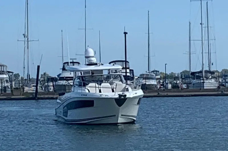 Slide: The Image of 2021 Jeanneau Leader 12.5 WA boat docked in a marina with sailboats. - 2