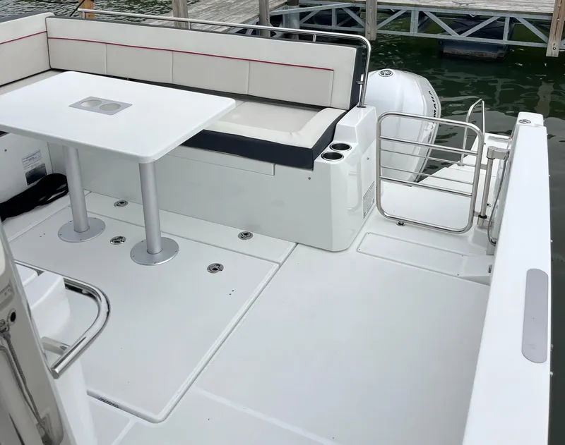 Slide: The Image of 2021 Jeanneau Leader 12.5 WA boat deck with seating and table, docked by the water. - 22