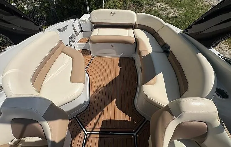 Slide: The Image of 2017 Crownline 285 SS boat interior with beige seating and wood flooring. - 10