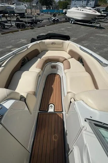 Slide: The Image of 2017 Crownline 285 SS boat with spacious seating and teak flooring in a marina setting. - 14