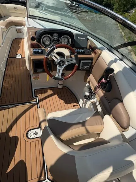 Slide: The Image of 2017 Crownline 285 SS boat interior with wood accents and modern dashboard. - 15