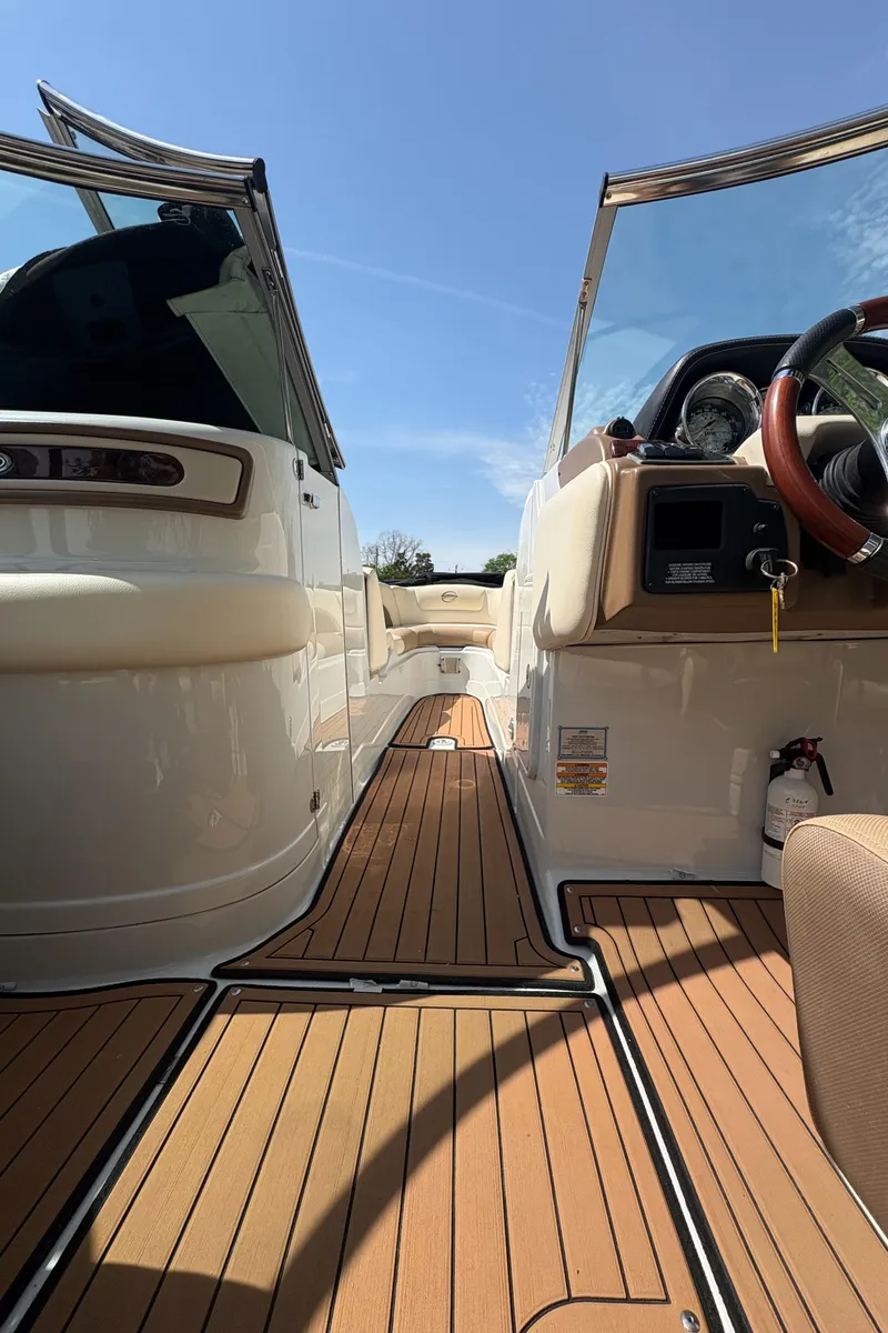 Slide: The Image of 2017 Crownline 285 SS boat interior with teak flooring and modern dashboard. - 19