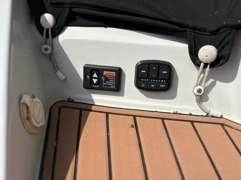 Slide: The Image of Control panel on 2017 Crownline 285 SS boat with teak flooring and black cover. - 20