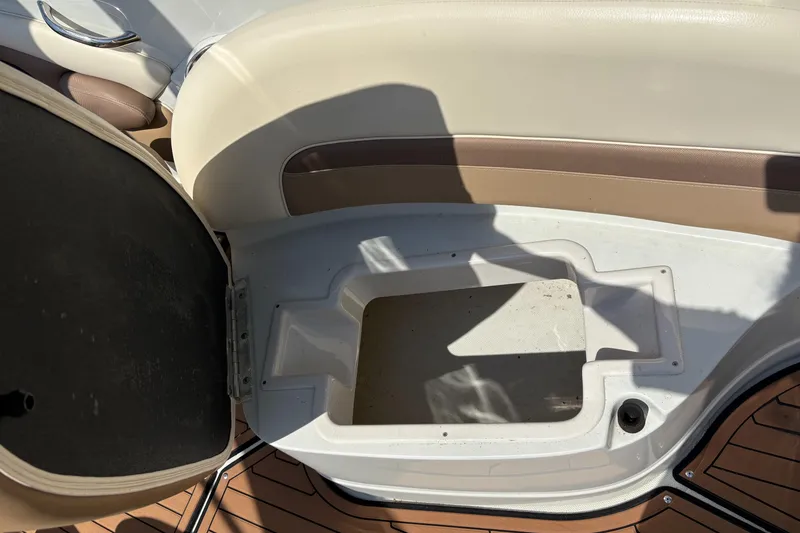 Slide: The Image of Open storage compartment on 2017 Crownline 285 SS boat with beige seating. - 21