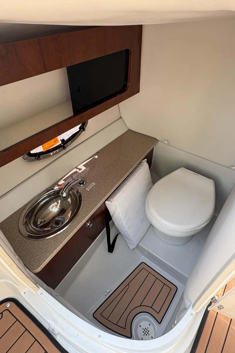 Slide: The Image of 2017 Crownline 285 SS boat interior with sink and toilet. - 22