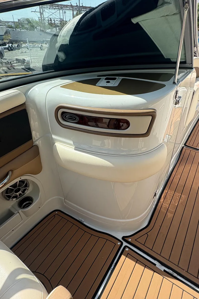 Slide: The Image of 2017 Crownline 285 SS boat interior with tan and white seating and wood-style flooring. - 23