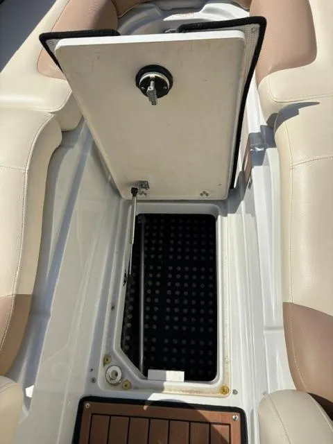 Slide: The Image of 2017 Crownline 285 SS boat storage compartment with open hatch, beige seating. - 25