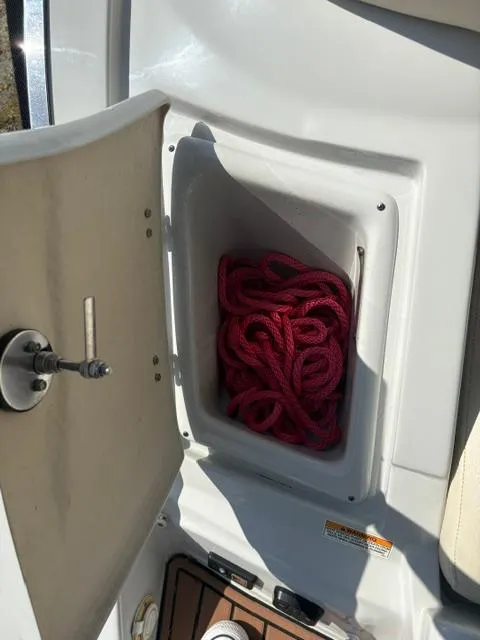 Slide: The Image of 2017 Crownline 285 SS boat storage compartment with red rope inside. - 26
