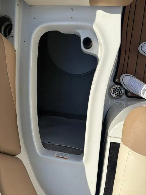Slide: The Image of 2017 Crownline 285 SS boat interior storage compartment with beige seating and wooden flooring. - 27