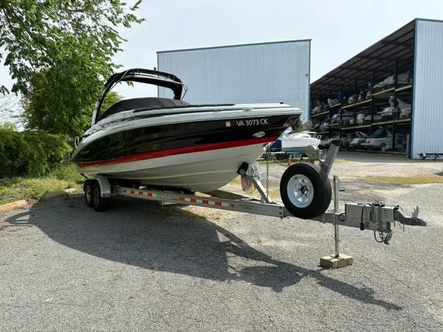 Slide: The Image of 2017 Crownline 285 SS boat on trailer, parked outdoors near storage facility. - 4