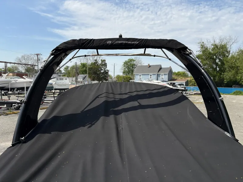 Slide: The Image of 2017 Crownline 285 SS boat with cover, parked outdoors under a clear sky. - 6