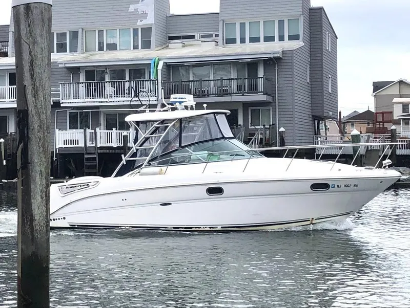 Slide: The Image of 2008 Sea Ray 290 Amberjack boat cruising near waterfront homes. - 1