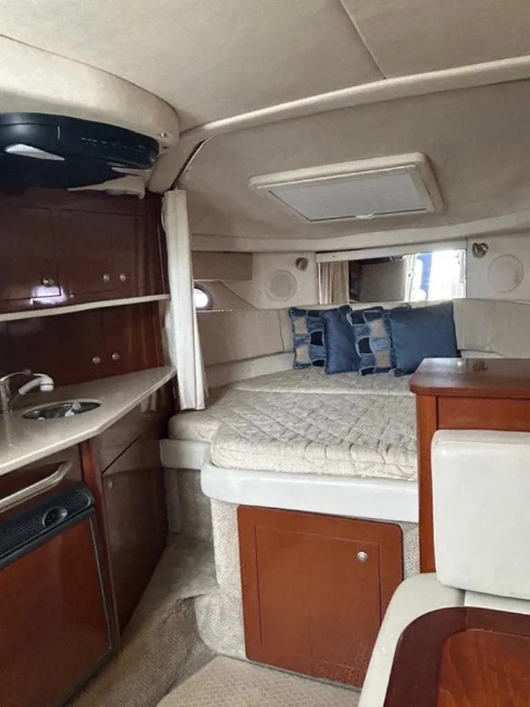 Slide: The Image of 2008 Sea Ray 290 Amberjack cabin interior with bed, kitchenette, and storage. - 10