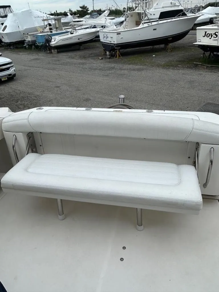 Slide: The Image of 2008 Sea Ray 290 Amberjack boat with white seating, docked among other boats. - 13