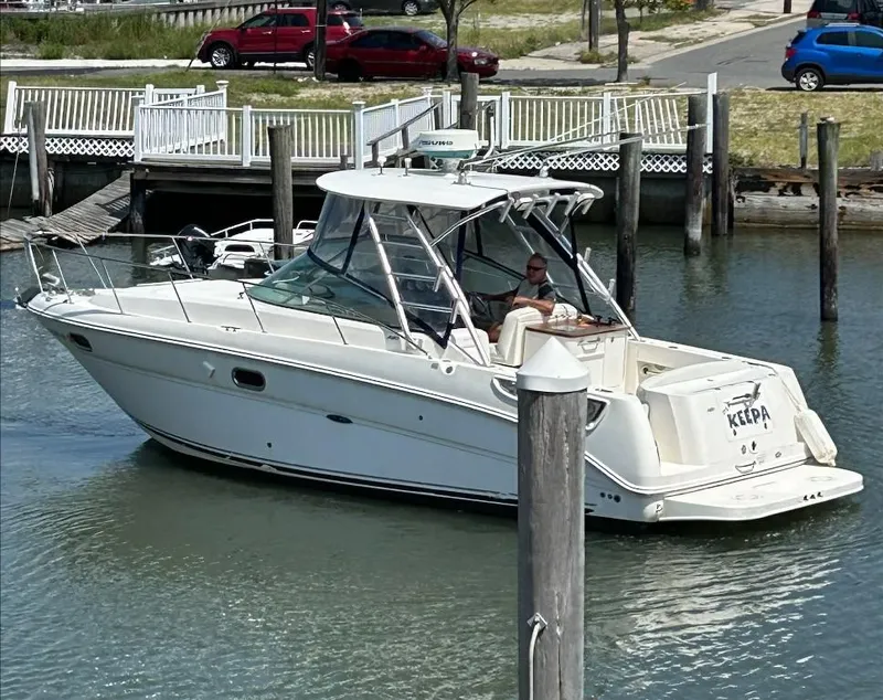 Slide: The Image of 2008 Sea Ray 290 Amberjack boat docked in a marina, featuring sleek design and white exterior. - 2