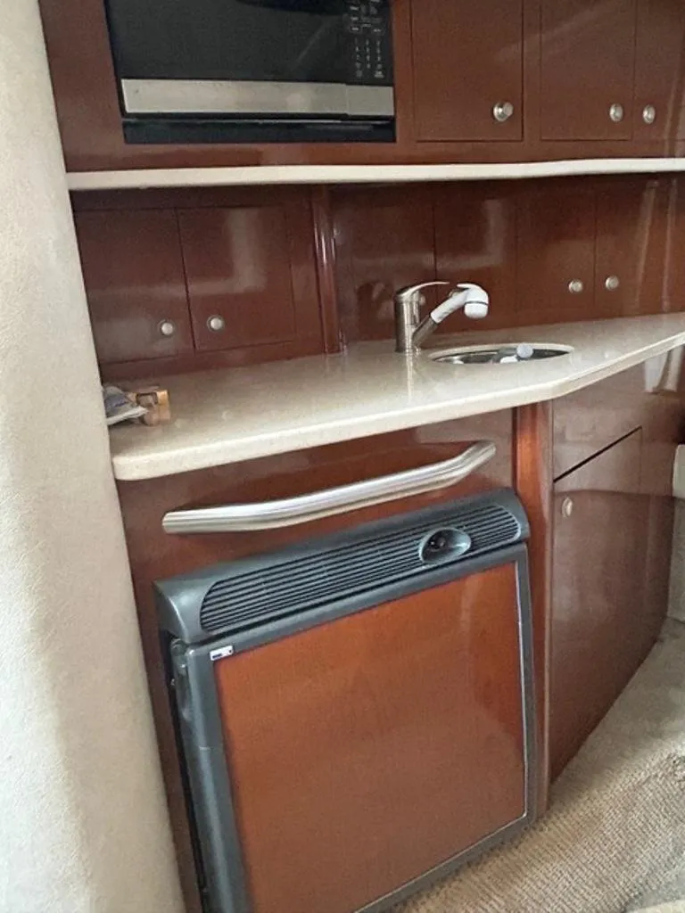 Slide: The Image of 2008 Sea Ray 290 Amberjack interior kitchen with sink, microwave, and mini fridge. - 8