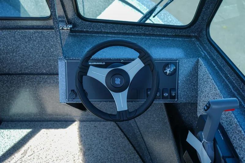 Slide: The Image of 2024 Alumaweld Talon 18 boat dashboard with steering wheel and control panel. - 13