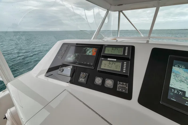 Slide: The Image of Control panel of a 2001 Viking 65 yacht with navigation displays and ocean view. - 16