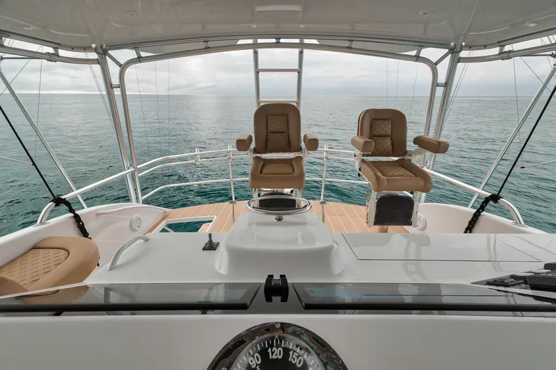 Slide: The Image of Bridge view of 2001 Viking 65 yacht with ocean backdrop and helm chairs. - 18